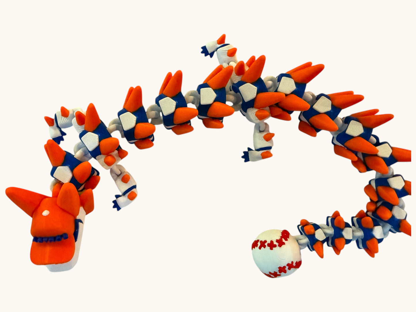 Flutterby Creations Home Run Dragon, a 3D printed articulated toy in orange, white, and blue, with a baseball tail.