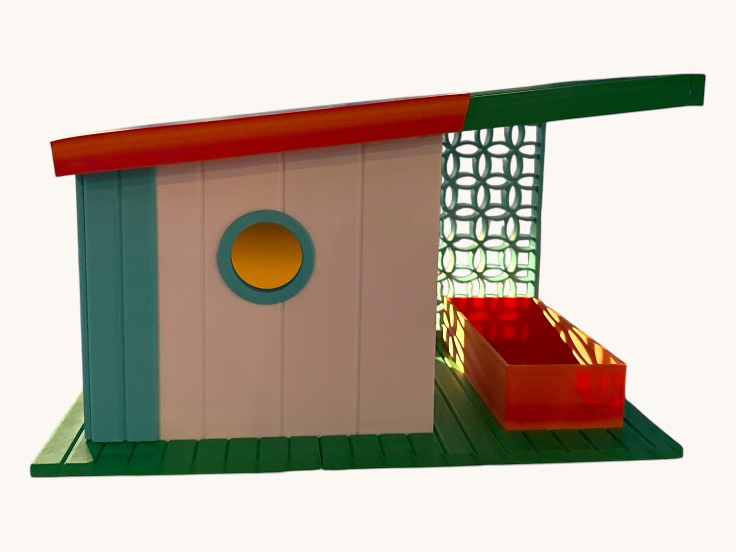 Flutterby Creations modern bird feeder with teal, white, red, and green accents. Features a round window and decorative lattice.