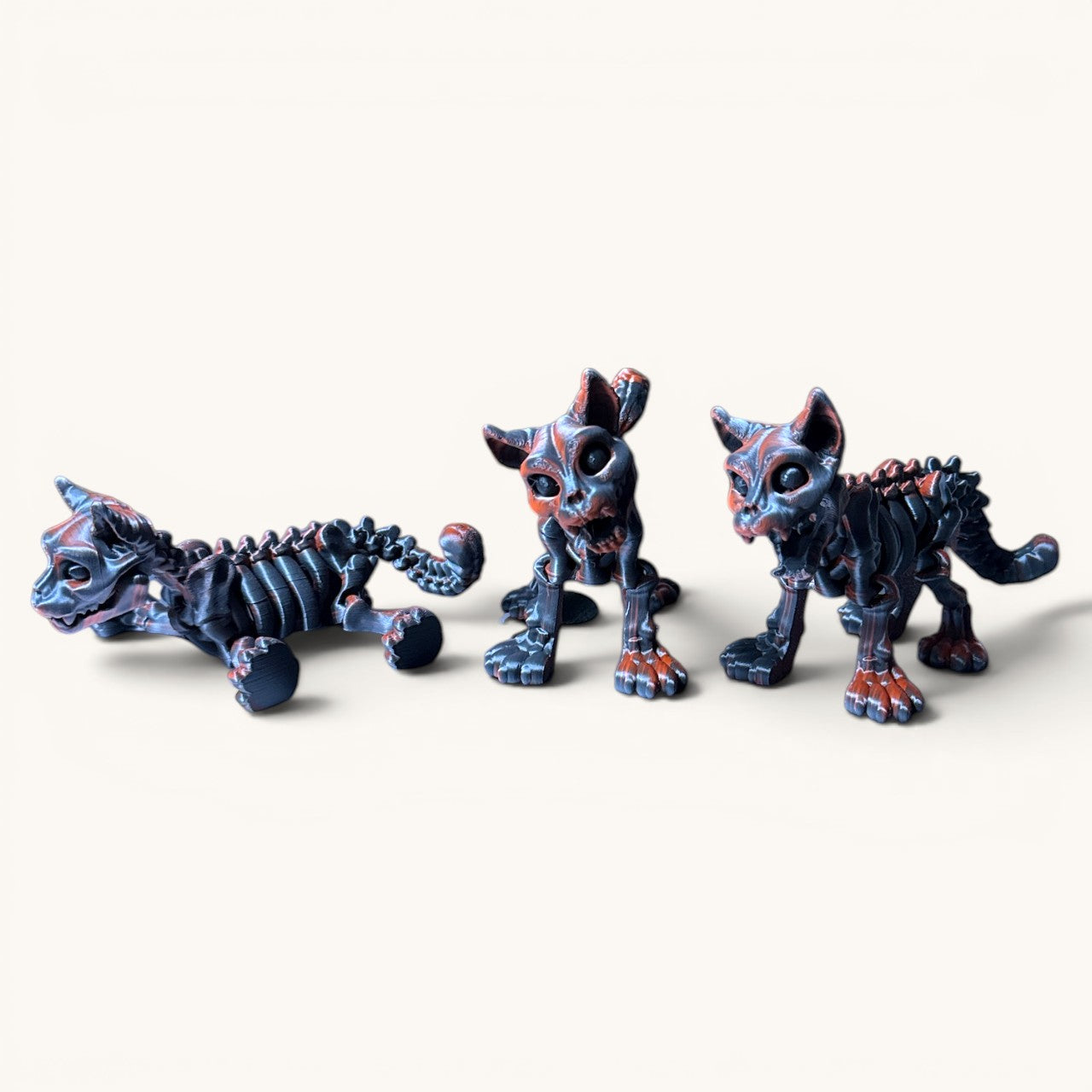 Flutterby Creations SkeliCat, a 3D-printed skeletal cat figurine with a haunting grin and spooky details, in dark blue and orange.