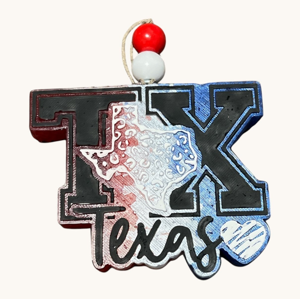 Flutterby Creations Texas Love car freshie, shaped like Texas with TX letters and "Texas" text. Features red, white, and blue colors.