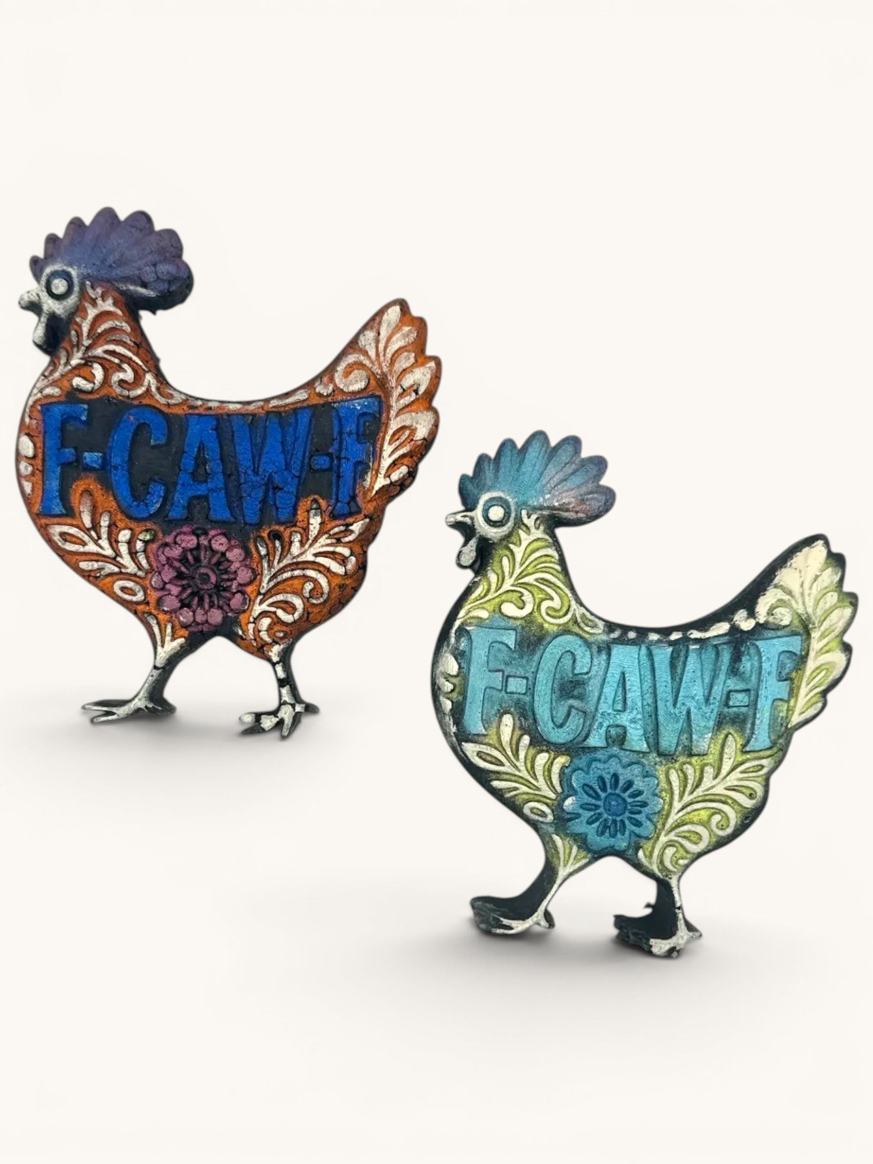Flutterby Creations decorative chicken freshie with F-CAW-F design. One is burnt orange with blue text, the other is light green with turquoise text.