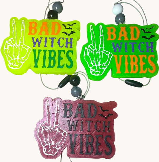 Flutterby Creations Bad Witch car freshie in neon green, lime green, and burgundy with skeleton hand peace sign and bats.