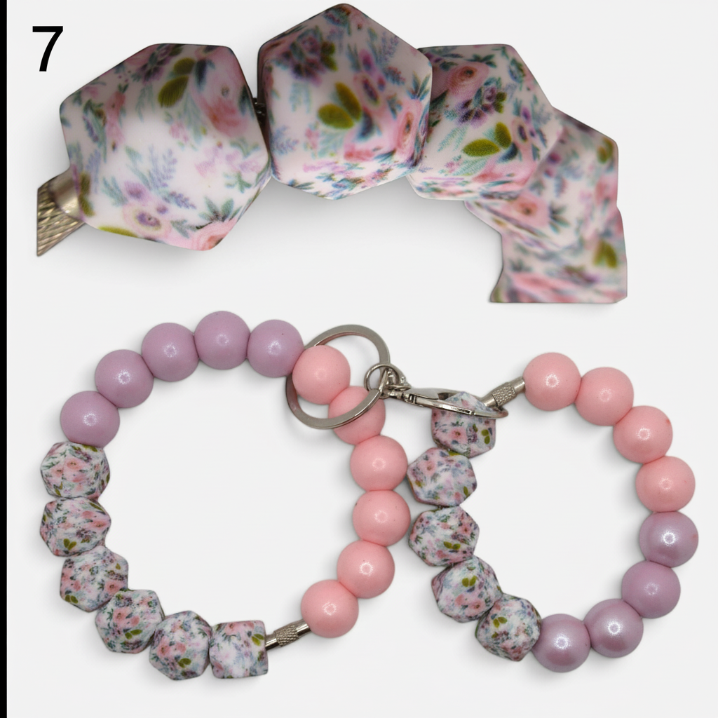 Flutterby Creations beadable wristlets featuring floral patterned geometric beads and smooth pastel pink and purple beads.