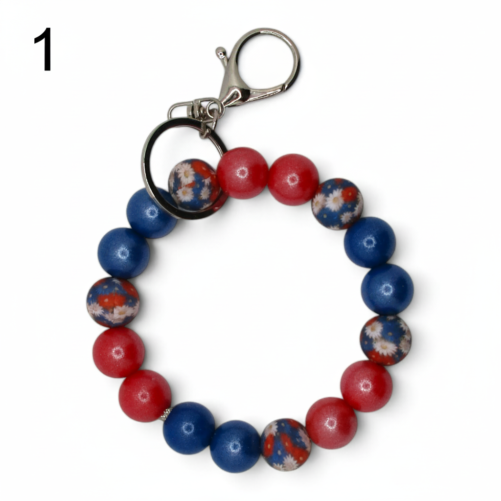 Flutterby Creations beadable wristlet with red, blue, and floral patterned beads on a silver keyring clasp