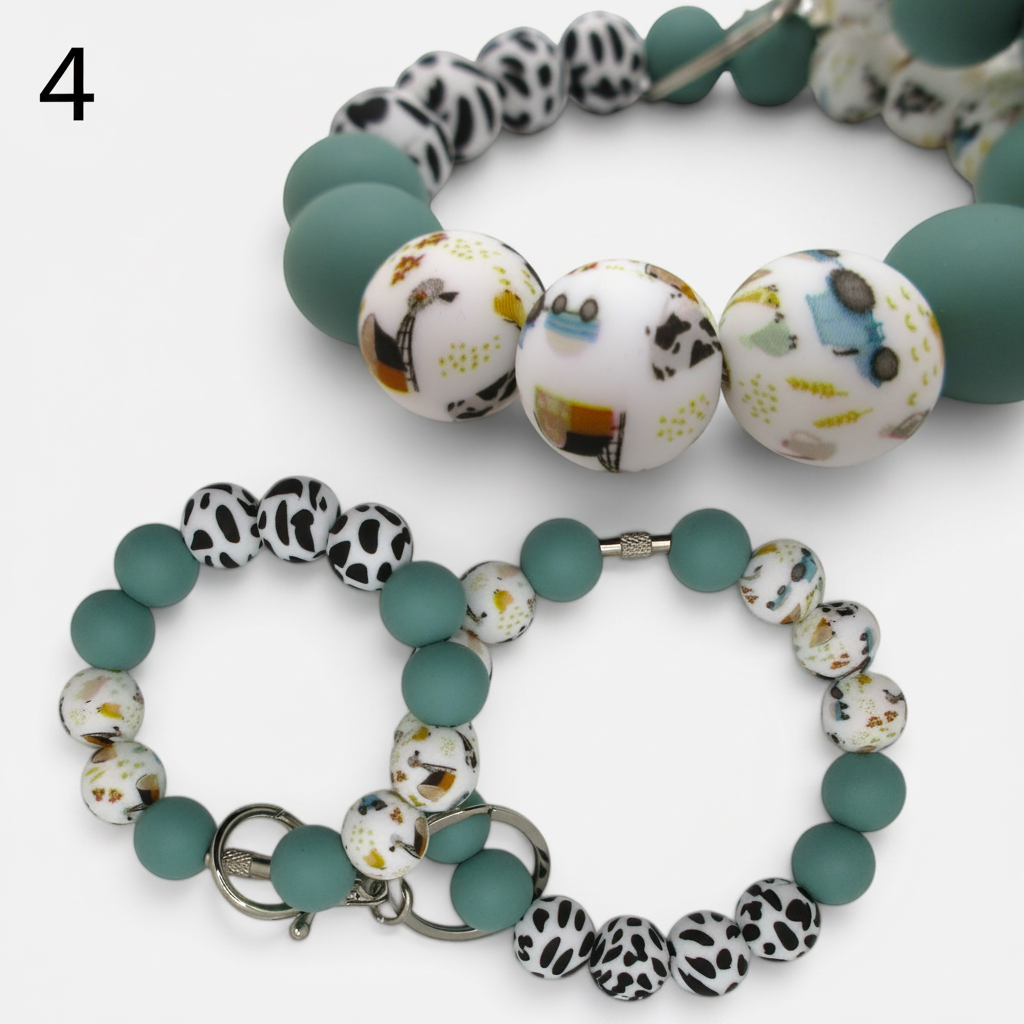 Flutterby Creations beadable wristlet car charm with teal, black and white cow print, and patterned silicone beads.