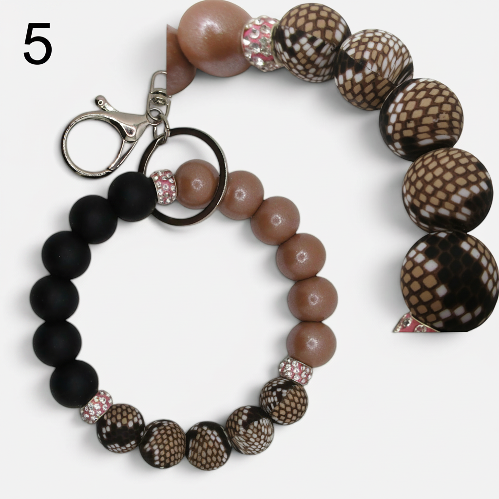 Flutterby Creations beadable wristlet featuring matte black, tan, and snakeskin patterned beads with rhinestone spacers.