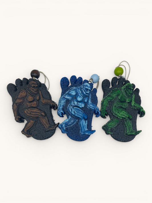 Flutterby Creations Bigfoot Steps car freshies in brown, blue, and green. 3D Bigfoot design on a foot shape.