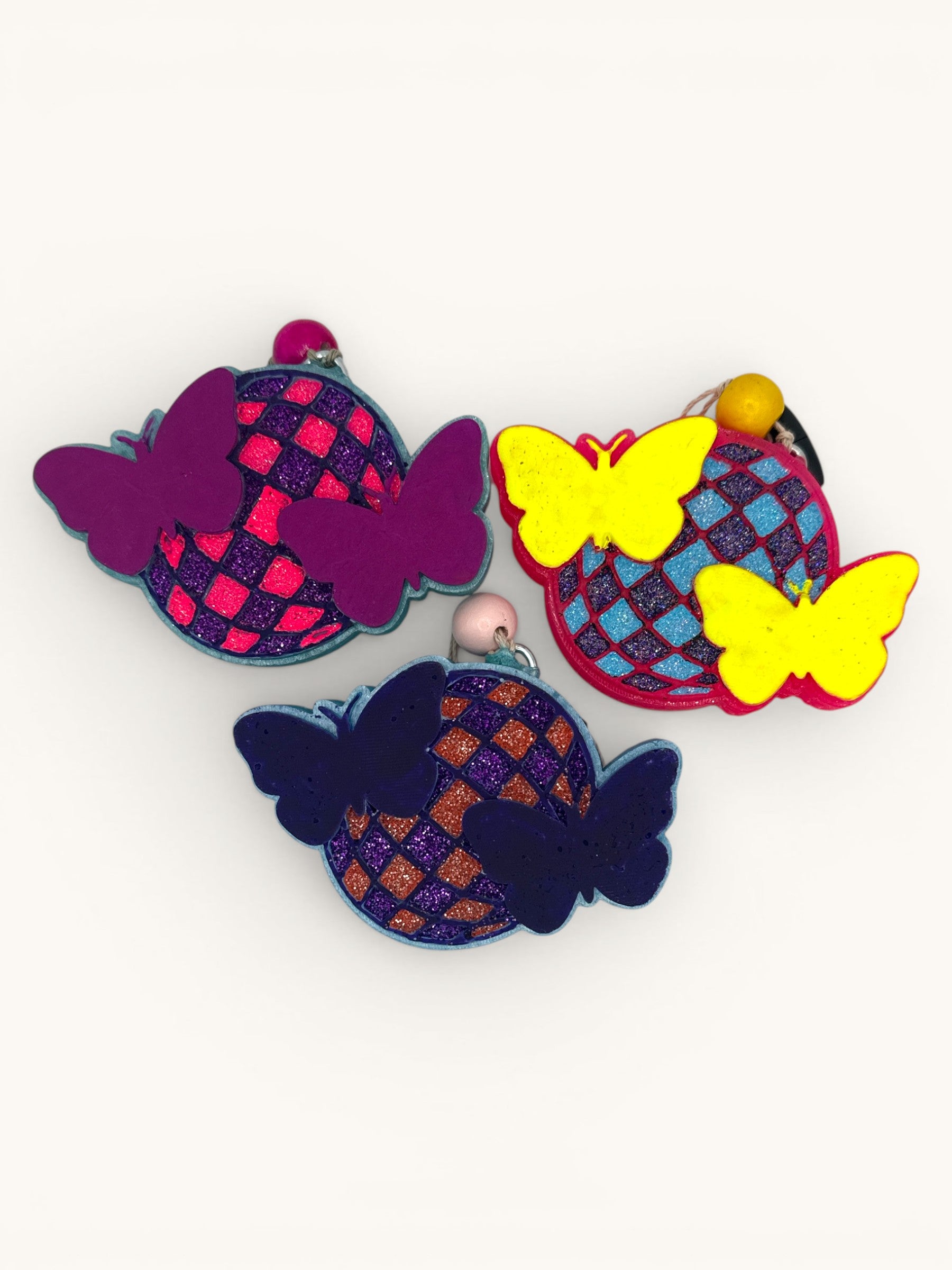 Flutterby Creations Disco Flutter car freshie with disco ball and butterfly design in purple, yellow, and navy.