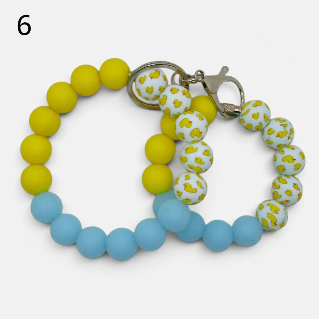 Flutterby Creations beadable wristlet featuring yellow and blue silicone beads and white beads with yellow duck prints.