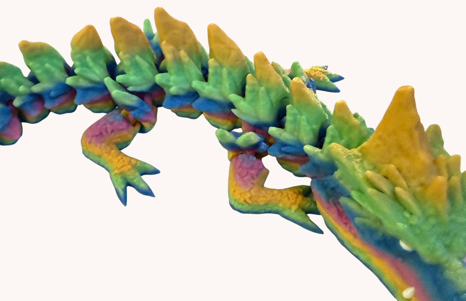 Flutterby Creations Elder Rock Dragon, a flexible, segmented dragon toy with rainbow colours and rock-like textures.
