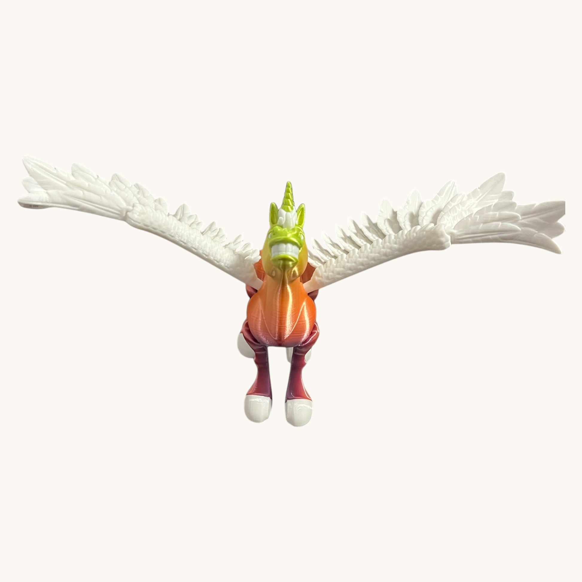 Flutterby Creations Flexicorn 3D printed unicorn toy with orange body, green head, white wings, and purple legs.
