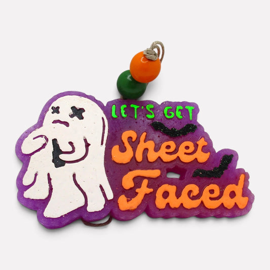 Flutterby Creations Let's Get Sheet Faced ghost car freshie with purple base, orange lettering, and black bat accents.