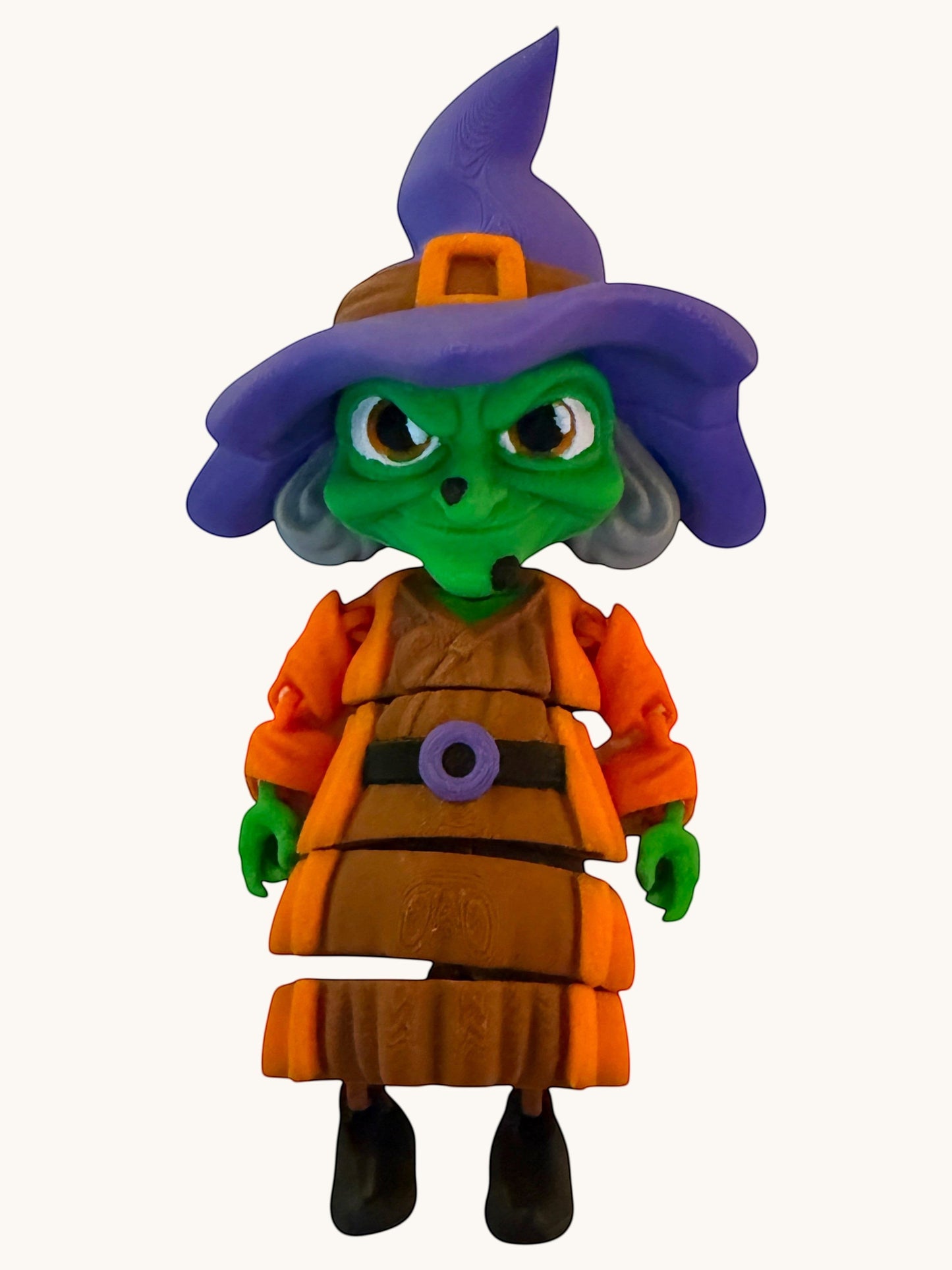 Flutterby Creations Halloween witch figurine with green face, purple hat, orange dress, and brown apron.