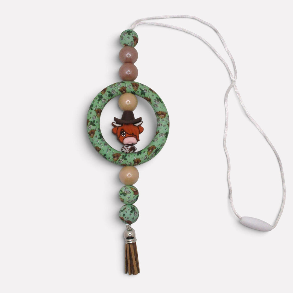 Flutterby Creations handmade beadable car charm featuring a highland cow print ring, wooden beads, and a brown tassel.