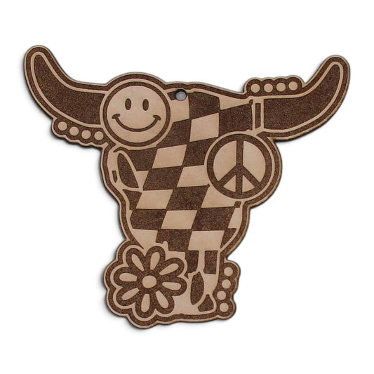 Flutterby Creations laser-cut leather car freshie in a cow skull shape with smiley face, checkerboard, and peace sign