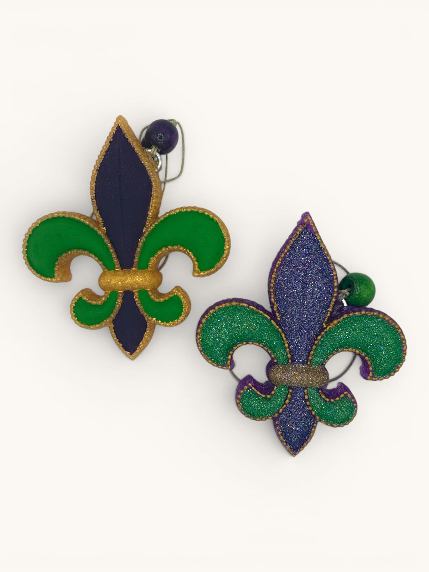 Flutterby Creations Mardi Gras fleur-de-lis car freshie in purple, green, and gold. One has glitter.