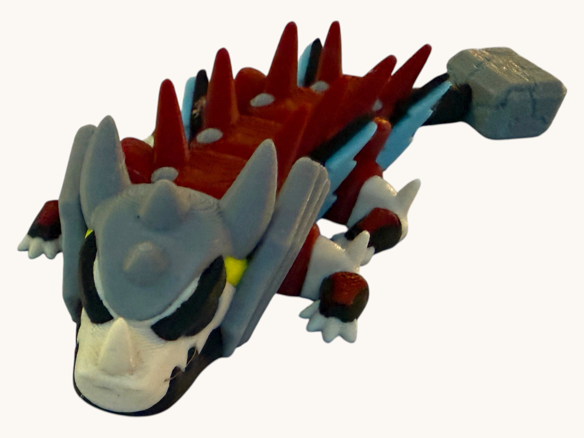 Flutterby Creations mini hammer dragon figurine with red spikes, grey head, and a stone hammer.
