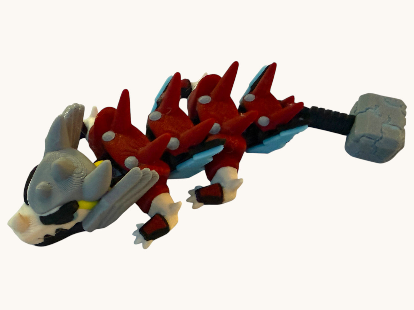 Flutterby Creations mini hammer dragon figurine with red, grey, black, and blue details.