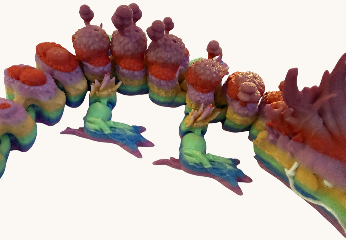 Flutterby Creations rainbow forest dragon figurine with green legs and pink accents, detailed fantasy collectible.