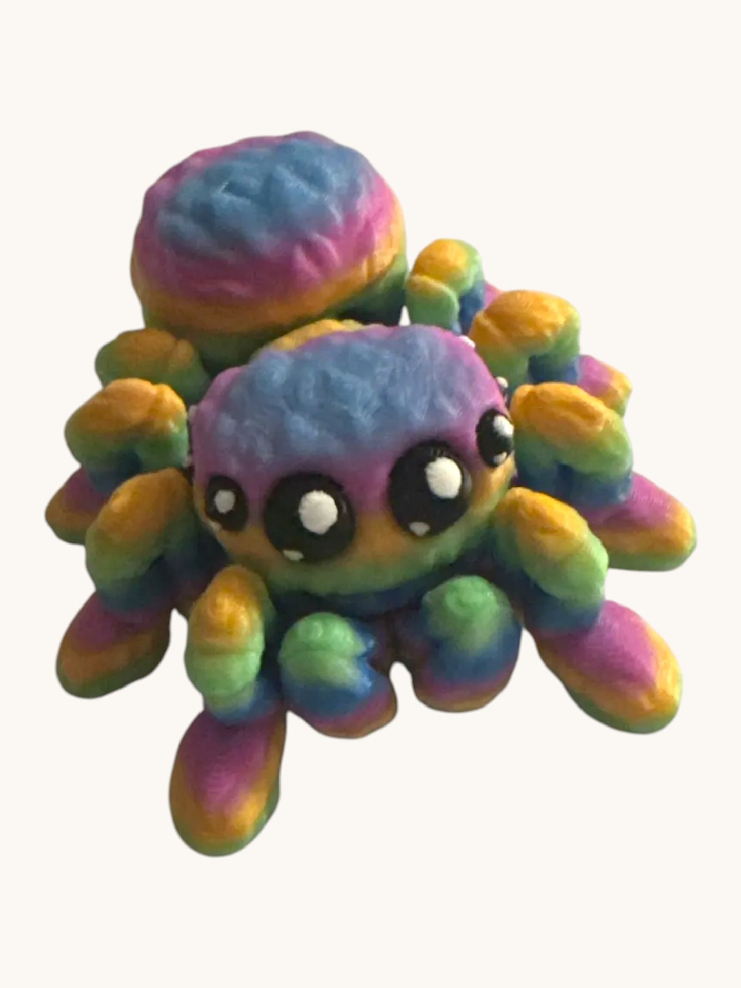 Flutterby Creations rainbow 3D printed spider toy with articulated legs and large black eyes, perfect for display or fidgeting.