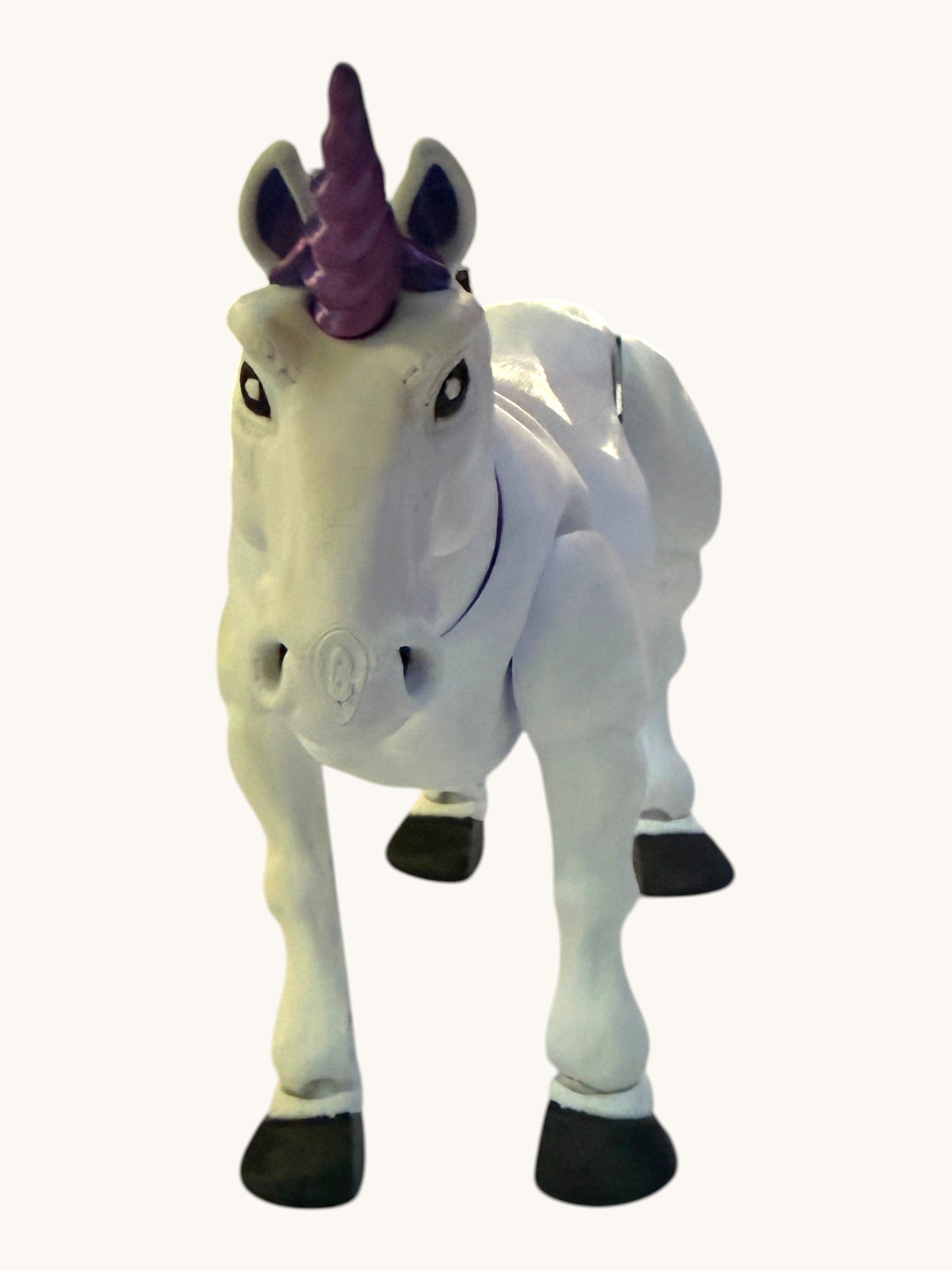 Flutterby Creations white 3D unicorn toy with purple horn and hooves, standing on a white surface.