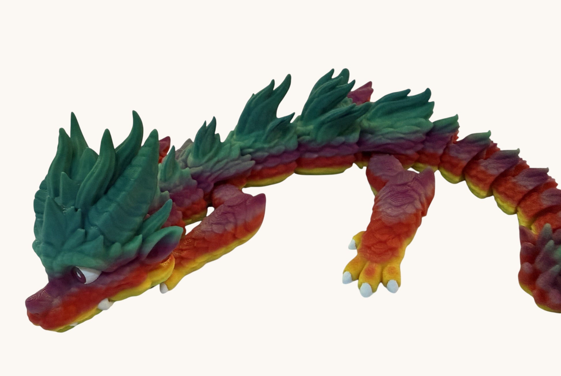 Flutterby Creations Young Dragon 3D printed toy with rainbow gradient from red to green, articulated body, and white claws.