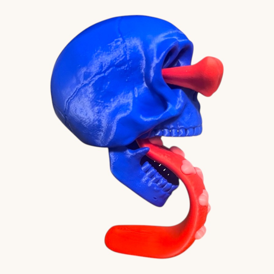 Flutterby Creations blue 3D printed skull with red tongue and nose, heart details, can be pen holder.